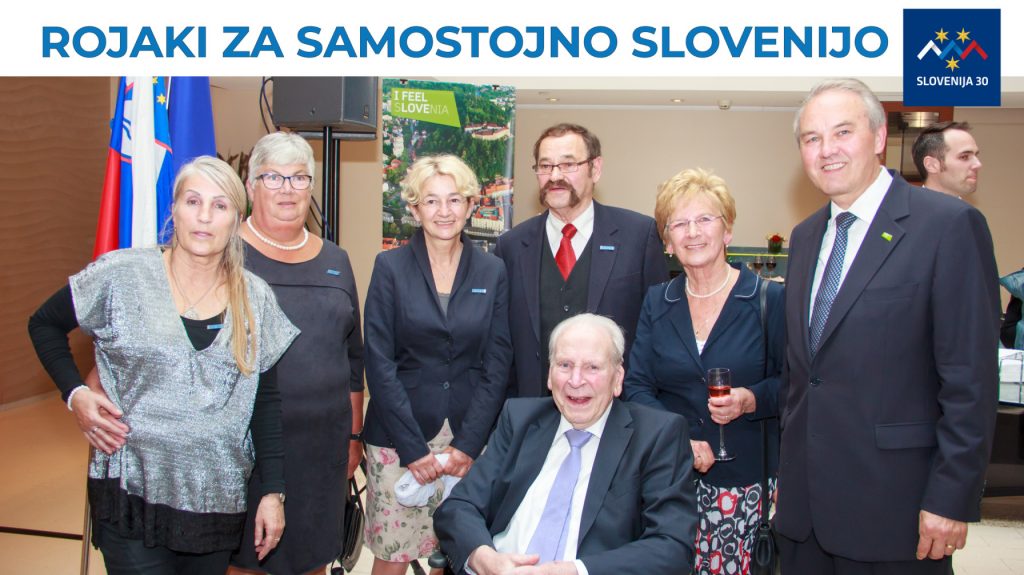 Člani komiteja (na vrhu na belem traku napis Rojaki za samostojno SLovenijo in logo (simbolj Triglava v beli, modri in rdeči barvi, tri rumene zvezde in pod tem napis Slovenija 30).