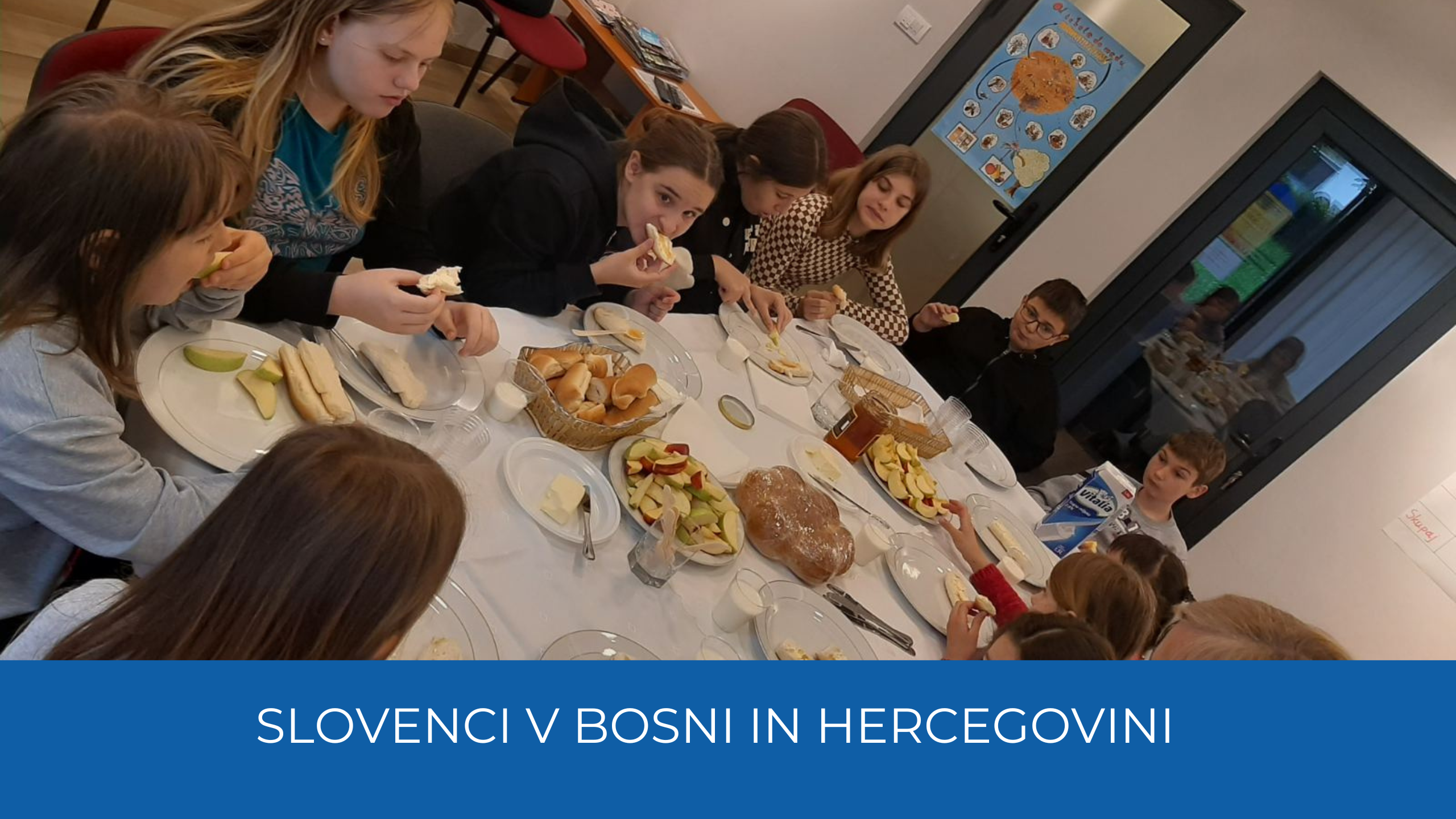 Otroci za obloženo mizo, jedo med na kruhu. Spodaj moder trak, na njem bel napis Slovenci v Bosni in Hercegovini.