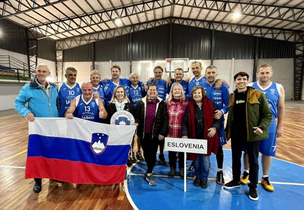 Ekipa veteranskih košarkarjev se slika s slovensko zastavo