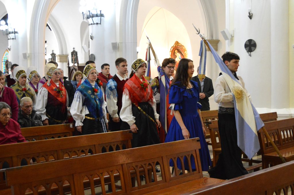 Ceremonialna procesija v cerkvi z argentinsko in slovensko zastavo