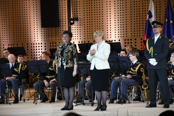 Predsednica republike Nataša Pirc Musar in ena od prejemnic odlikovanja na odru, zadaj orkester in ob strani častna straža