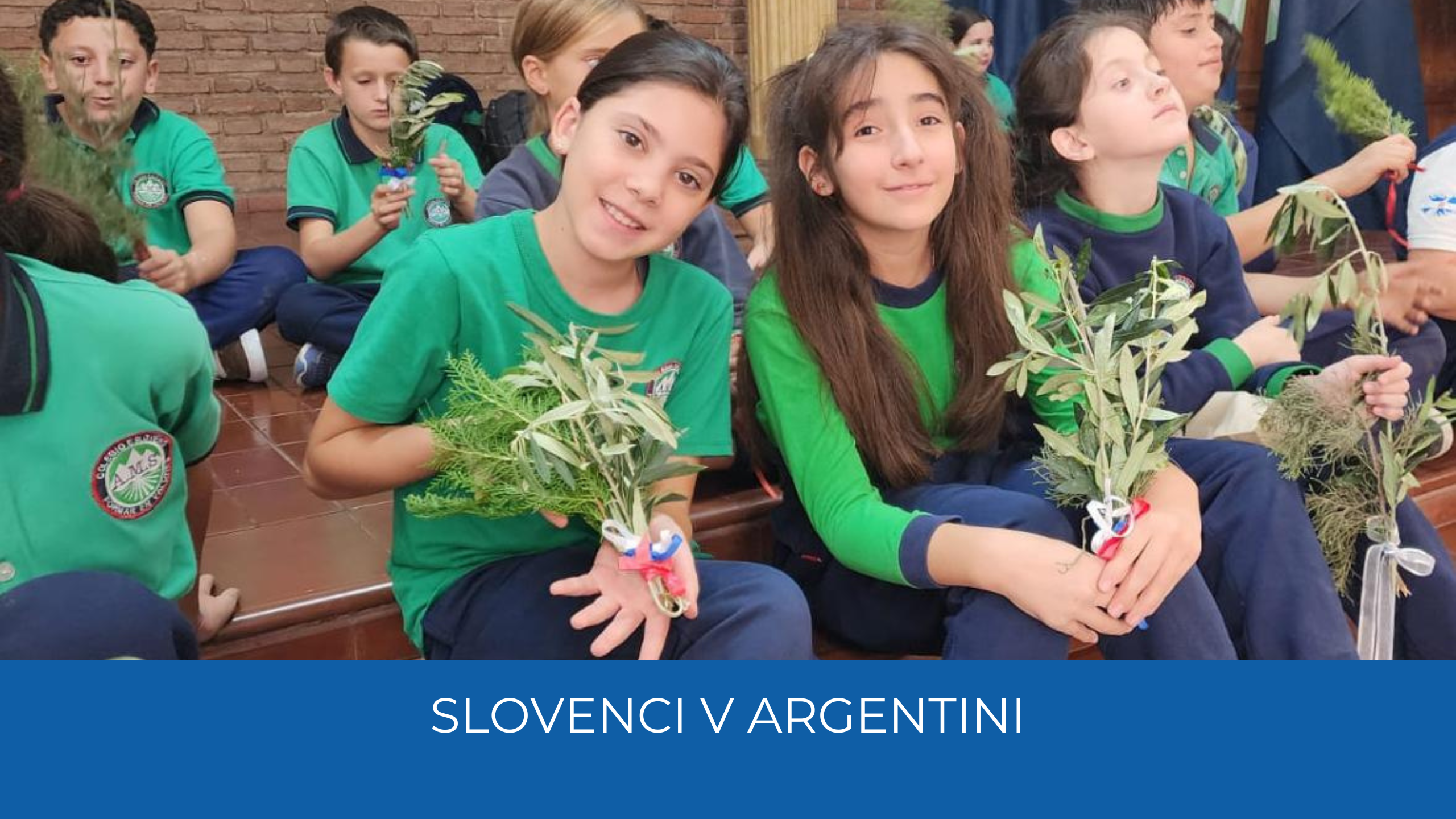 dVE DEKLETI Z BUTARICAMI. sPODAJ NA MODREM TRAKU NAPIS sLOVENCI V aRGENTINI.