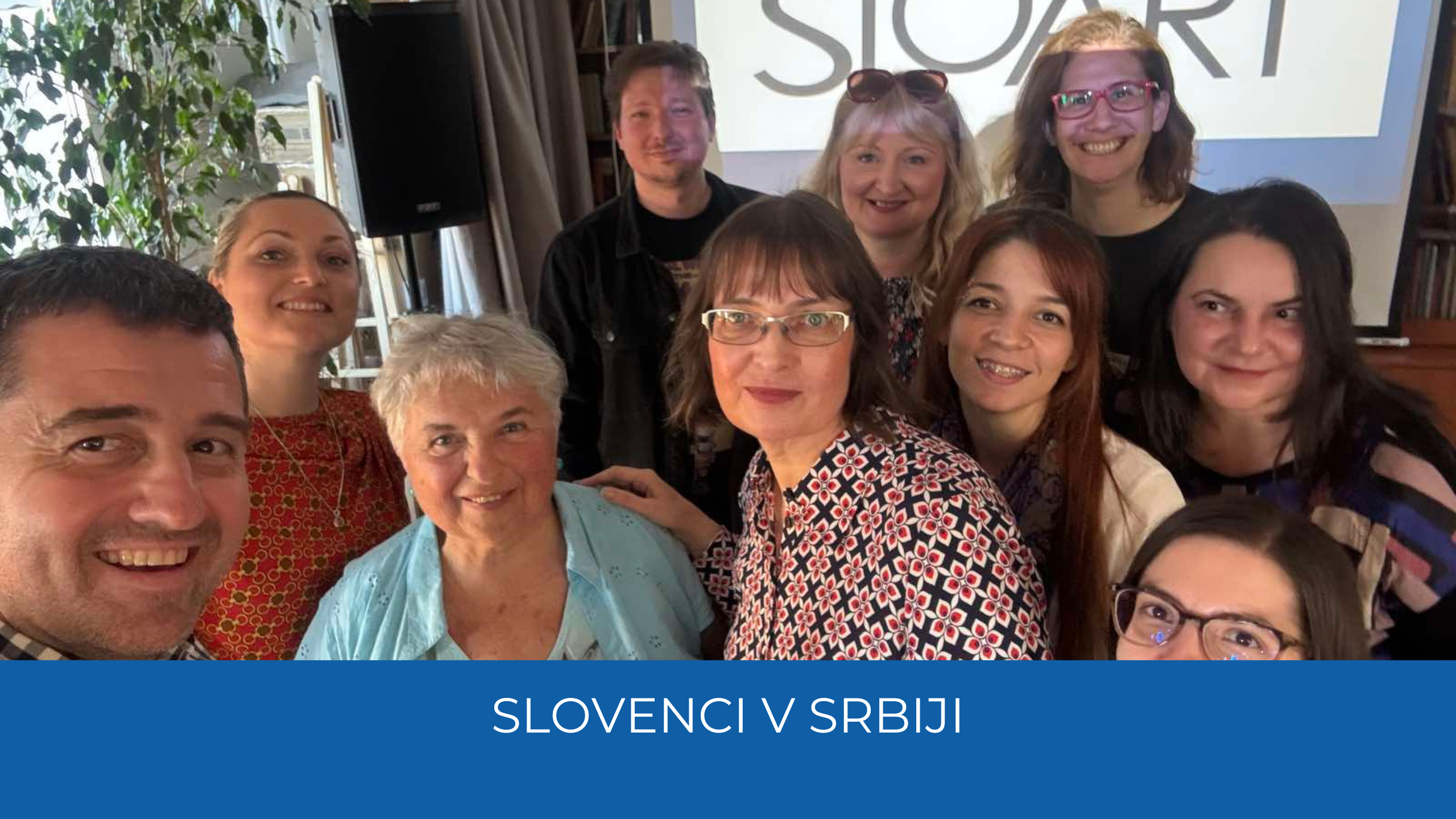 Udeleženci. Spodaj moder trak z napisom Slovenci v Srbiji.